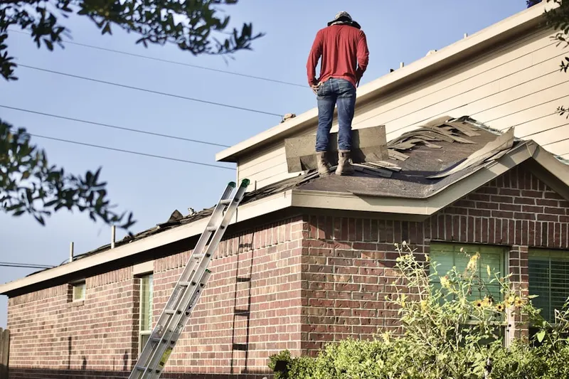 Professional roofer working on a residential roof in Ewings Mill